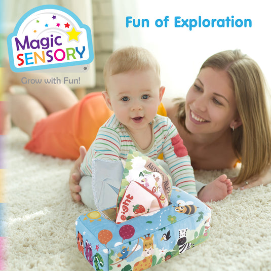 A baby reaching for the Sensory Tissue Box while an adult looks on, enjoying play together on the floor